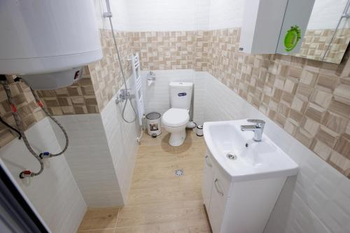 a small bathroom with a toilet and a sink at WhiteBoxApartment in Kyustendil