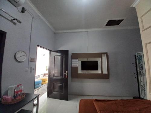 uma sala de estar com uma televisão na parede em OYO 93962 Jm Guest House em Pundong