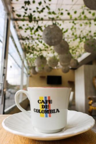 a coffee cup sitting on a plate on a table at Hotel Casa Botero 305 in Bogotá