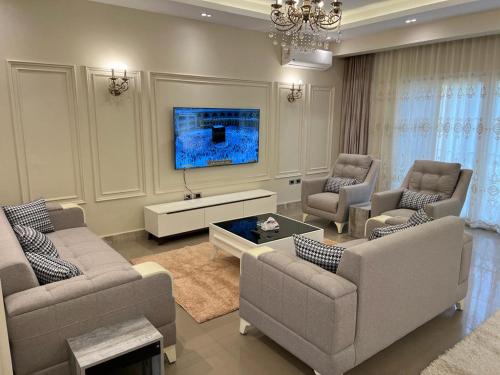 a living room with two couches and a tv at Elkarma 4 in Sheikh Zayed