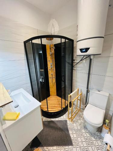 La salle de bains est pourvue d'une douche et d'une baignoire en bois. dans l'établissement La Petite Rhonelle - Studio en hypercentre, à Valenciennes