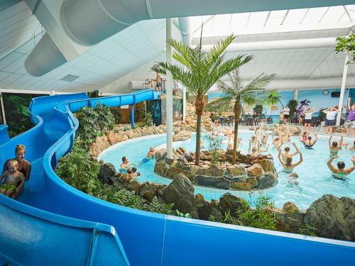eine Wasserrutsche in einem Pool in einem Resort in der Unterkunft Spledid villa with sauna and whirlpool in Limburg in Roggel