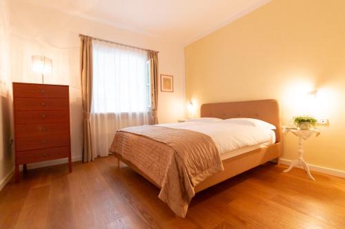a bedroom with a bed and a dresser and a window at Ba mir Apartment in Appiano sulla Strada del Vino