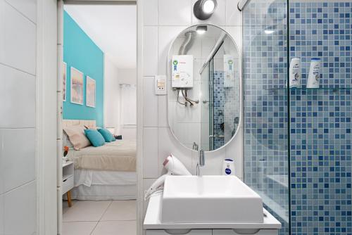 baño con lavabo, espejo y cama en Modern Copacabana Apartment, en Río de Janeiro