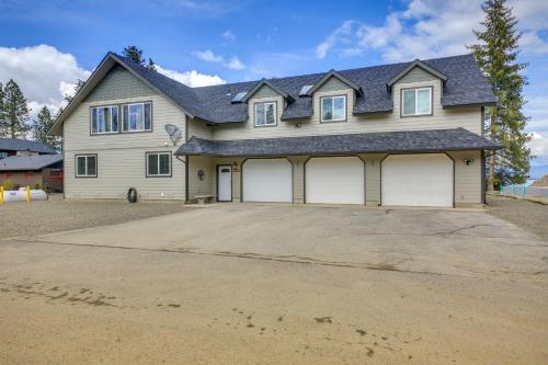 a house with two garage doors on a driveway at Beachfront Sagle Retreat with Boat Dock and Lift in Sagle