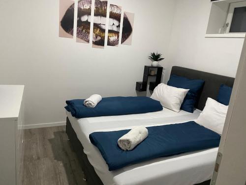 two beds in a room with blue and white at Vitalis Apartman in Fertőszentmiklós