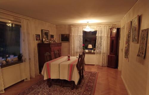 une salle à manger avec une table et un chiffon de table blanc dans l'établissement Trevligt hus nära skogen, à Glimåkra