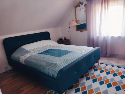- un lit avec un cadre bleu dans une chambre dans l'établissement Trevligt hus nära skogen, à Glimåkra