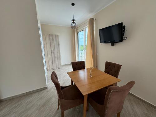 a dining room with a table and chairs and a tv at Vila Horizont in Baks-Rrjoll