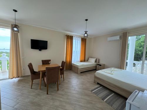 um quarto de hotel com uma cama e uma mesa e uma cama e uma secretária em Vila Horizont em Baks-Rrjoll