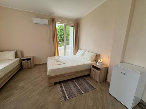 a small bedroom with two beds and a window at Vila Horizont in Baks-Rrjoll