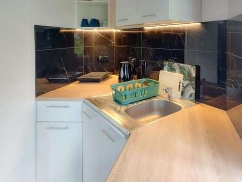 a kitchen with a sink with a green tray on it at Chatka in Stegienka