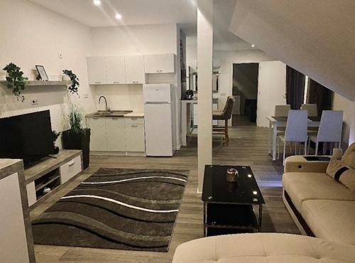 a living room with a couch and a kitchen at Vitalis Apartman in Fertőszentmiklós