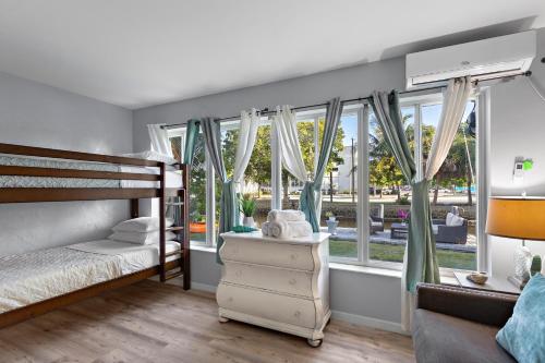 a bedroom with a bunk bed and windows at RiverWalk Villa I Private Dock & Hot Tub in Fort Lauderdale