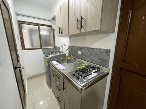 Il comprend une petite cuisine équipée d'une cuisinière et d'un évier. dans l'établissement Apartaloft en el centro 205, à Pereira