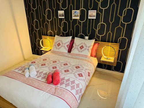 a bedroom with a bed with red slippers on it at Appartement Premium 4 Stars - Antigone in Montpellier