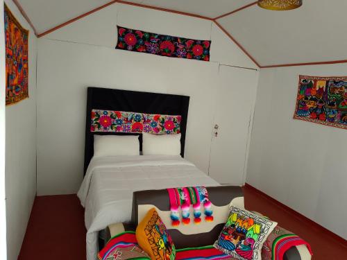 Coila Titicaca lodge في بونو: غرفة نوم بسرير في غرفة صغيرة