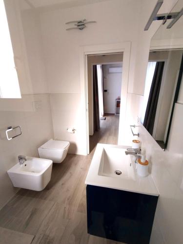 a white bathroom with a sink and a toilet at L'Angolo di Mimma in Porto Cesareo