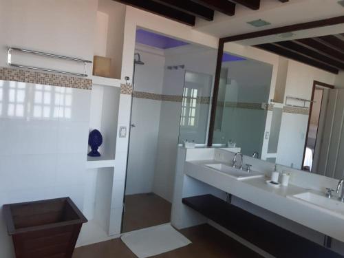 a bathroom with two sinks and a large mirror at Pousada Éden in Angra dos Reis