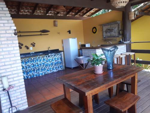 a room with a wooden table and a refrigerator at Pousada Éden in Angra dos Reis