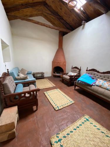 sala de estar con sofás y chimenea en Casita Hierbabuena en Ibarra