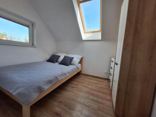 a bedroom with a bed with two pillows on it at Węgorzewo- Apartamenty nad stawem in Węgorzewo
