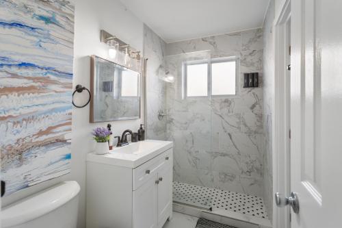 a white bathroom with a sink and a shower at RiverWalk Villa I Private Dock & Hot Tub in Fort Lauderdale
