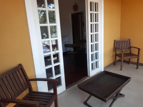two chairs and a bench in a room with a door at Pousada Éden in Angra dos Reis