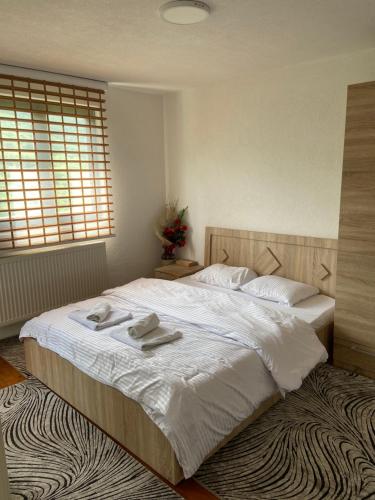a bedroom with a large bed with two towels on it at The Hill House in Prizren