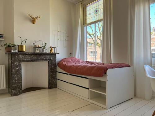 a room with a bed with a fireplace and a window at Grote gezinswoning in Rotterdam
