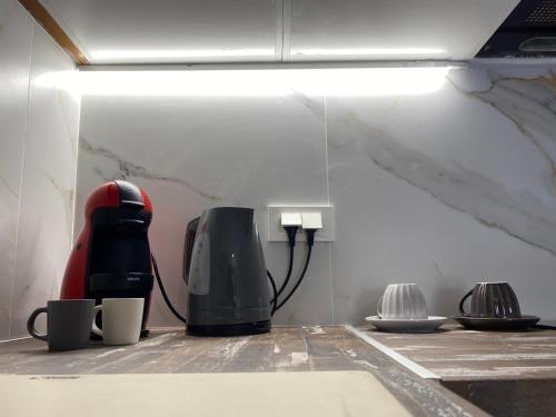 a counter with a coffee maker and cups on it at Paradosi Rooms in Igoumenitsa