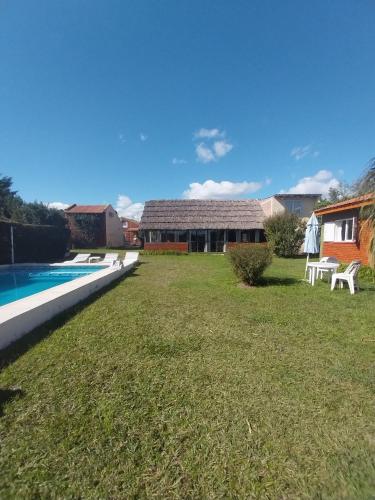a yard with a swimming pool and a house at Complejo Cantonavi in Mina Clavero