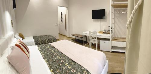 ローマにあるMonti49 GuestHouseのベッド2台とデスクが備わるホテルルームです。