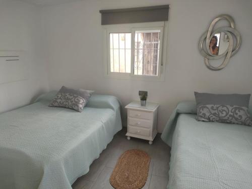 a bedroom with two beds and a window at Casa de la abuela in Sanlúcar de Barrameda