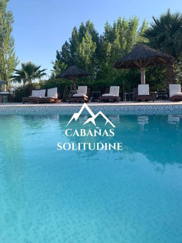 a swimming pool at a villa with blue water at Complejo Solitudine in Cacheuta