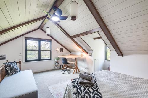 a attic bedroom with a ceiling fan and a desk at Knoxville Area Getaway on 22 Acres with Pond Access! in Galesburg