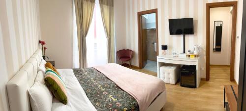 ローマにあるMonti49 GuestHouseのベッドとテレビが備わるホテルルームです。