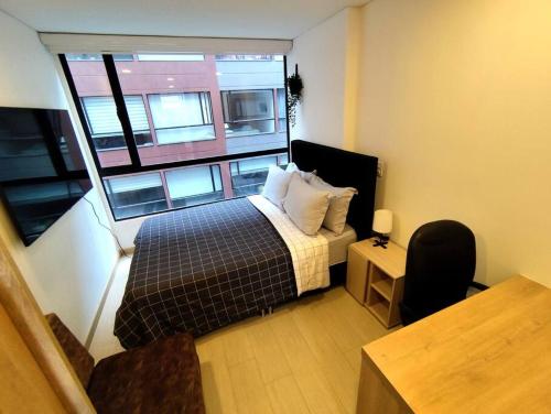 Kleines Zimmer mit einem Bett und einem Fenster in der Unterkunft Bogota Apartamento Tipo Loft Chapinero in Bogotá