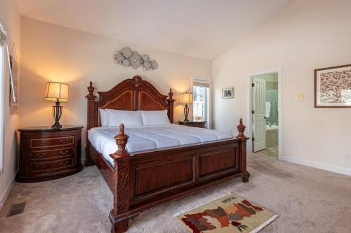 a bedroom with a large wooden bed with white sheets at Luxurious 4BR Retreat - Pool Table & Chic Amenities in Boulder