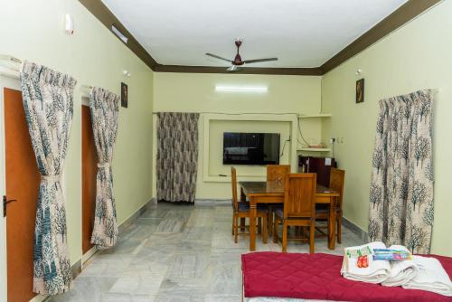 ein Wohnzimmer mit einem Tisch und einem Esszimmer in der Unterkunft Live Inn RMS in Tiruchchirāppalli