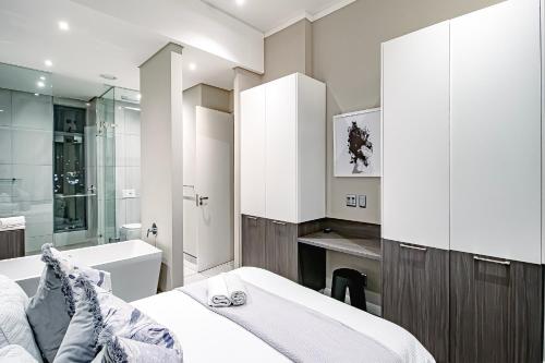 y baño con cama, bañera y lavamanos. en 2bedroom apartments at Menlyn Maine on 16th, en Pretoria