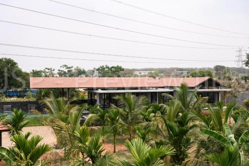 a house with a red roof and palm trees at Qalb in Mandya