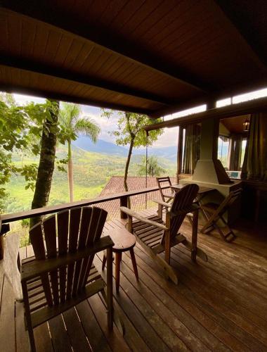 a porch with two chairs and a table and a view at Pousada Varandas da Mantiqueira in São Francisco Xavier