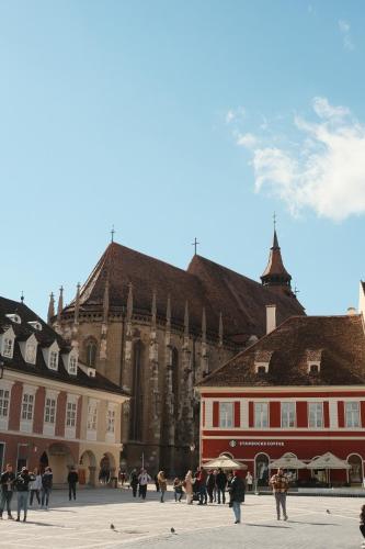 a group of people walking in front of a cathedral at MooDee Suite - Piata Sfatului in Braşov