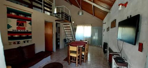 a living room with a staircase and a television at Complejo Solitudine in Cacheuta