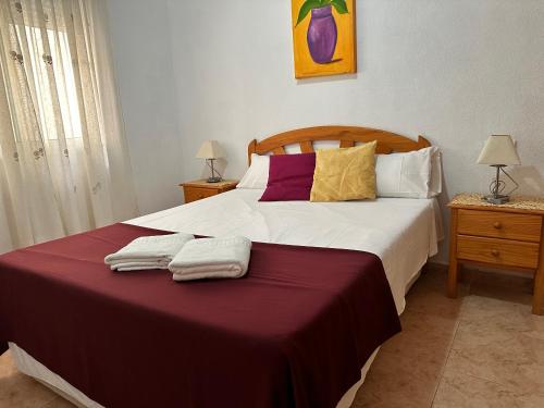 sypialnia z dużym łóżkiem i dwoma ręcznikami na nim w obiekcie Homely Apartments Alcatri w mieście Torrevieja