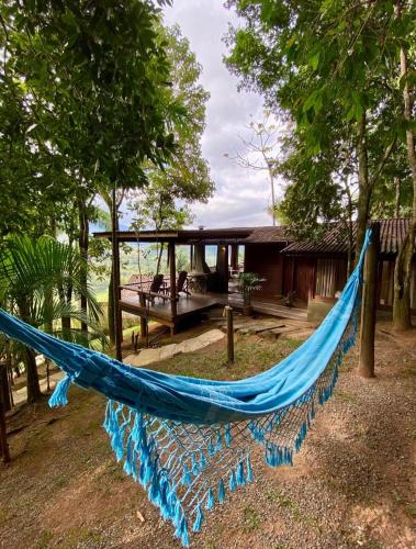 a blue hammock in front of a house at Pousada Varandas da Mantiqueira in São Francisco Xavier
