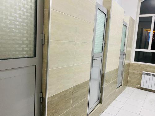 una puerta en una habitación con una pared de azulejos en Sakhohostel en Karategin