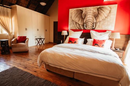 a bedroom with a large bed with a painting of an elephant at Blue Hills Lodge in Midrand