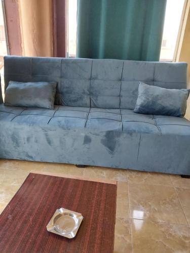 a blue couch in a living room with a plate on the floor at Lazorde bay Sidi Abd El Rahman لازوردى باى apartment in El Alamein